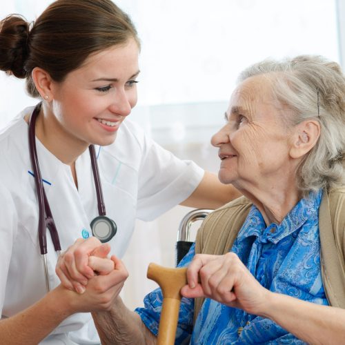 Senior woman is visited by her doctor or caregiver